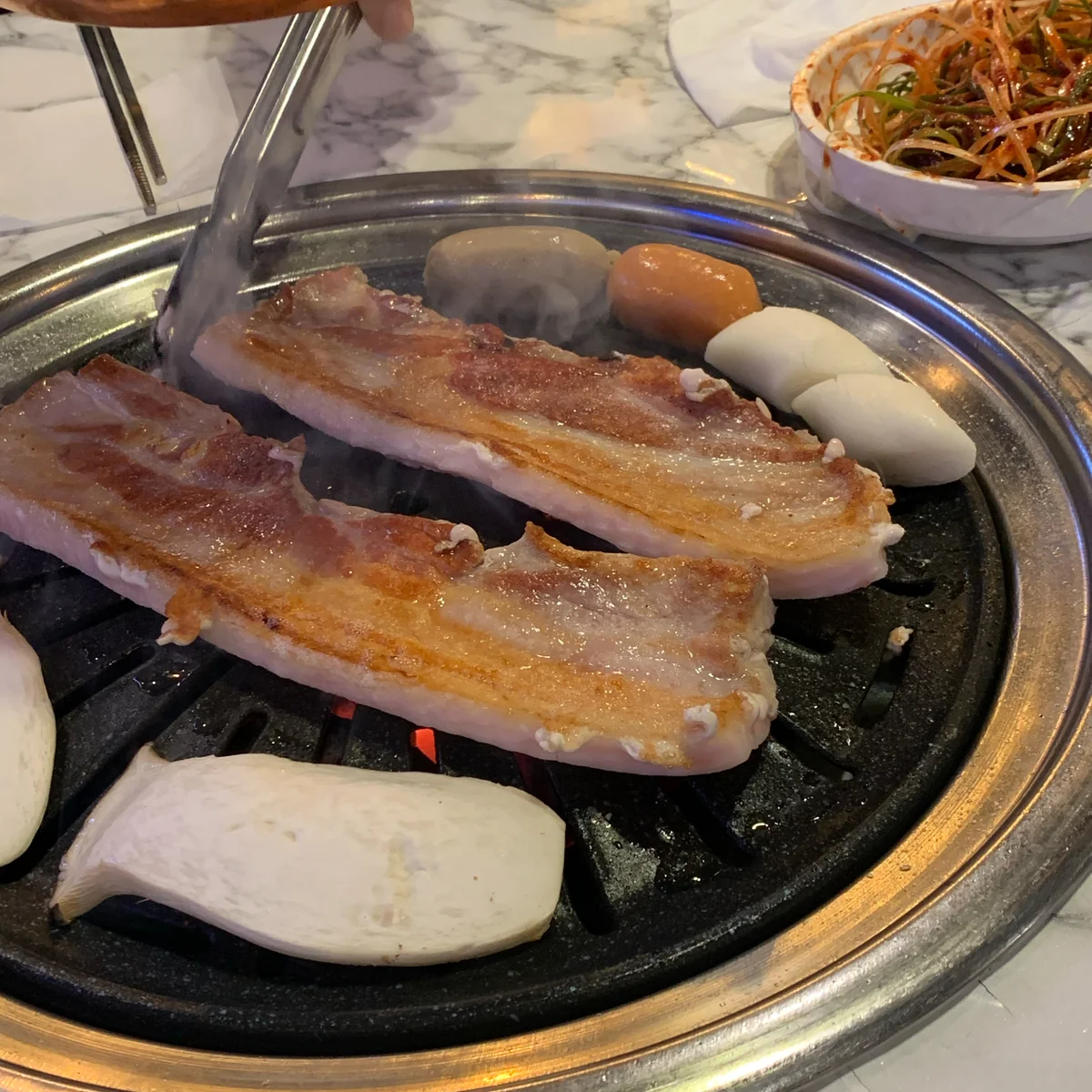 快乐的顾客在 gogi 沙龙享用美味猪肉